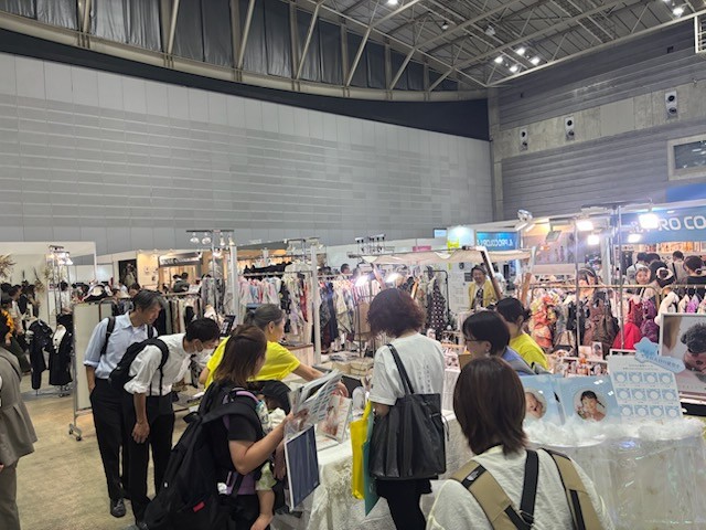 TK Bridgeブース周辺に多数の来場者が集まり、スタッフと会話している賑わいの様子